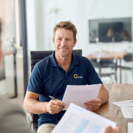 Staff member assessing a customer's energy needs for a solar power system, reviewing options for solar panels, solar batteries, and energy storage.